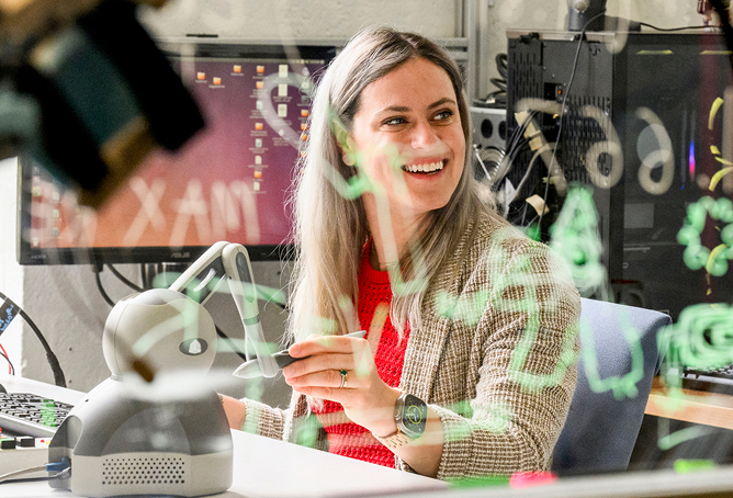 A student smiling while working in a lab.