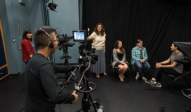 Students operating a video camera during a media production in a studio.